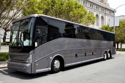 A gray charter bus parked along the street