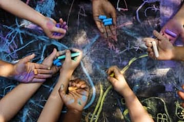 close up of children's hands holding chalk